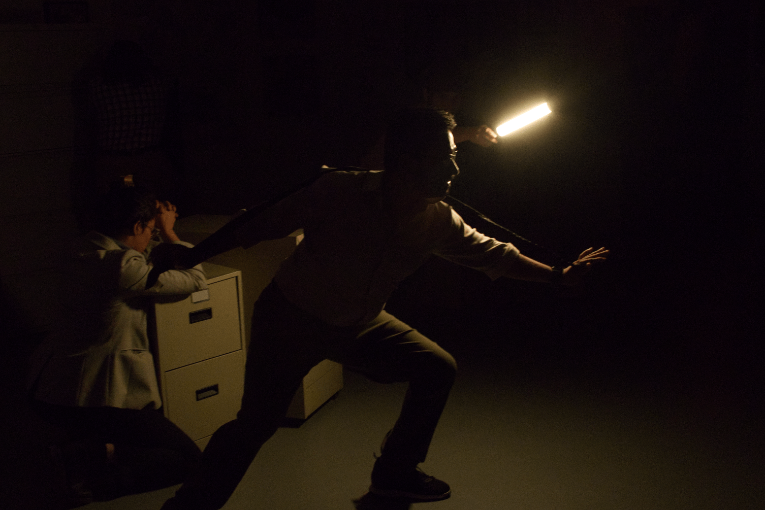 a character wearing a tie stands in an action pose and is lit by a single light